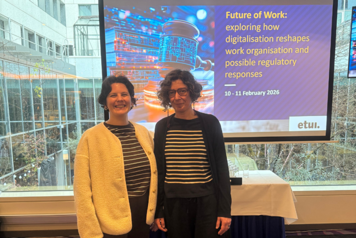 Michela Trentin and Dora Fonseca standing in front of a presentation screen showing the ETUI Future of Work conference title 'Exploring how digitalisation reshapes work organisation and possible regulatory responses'